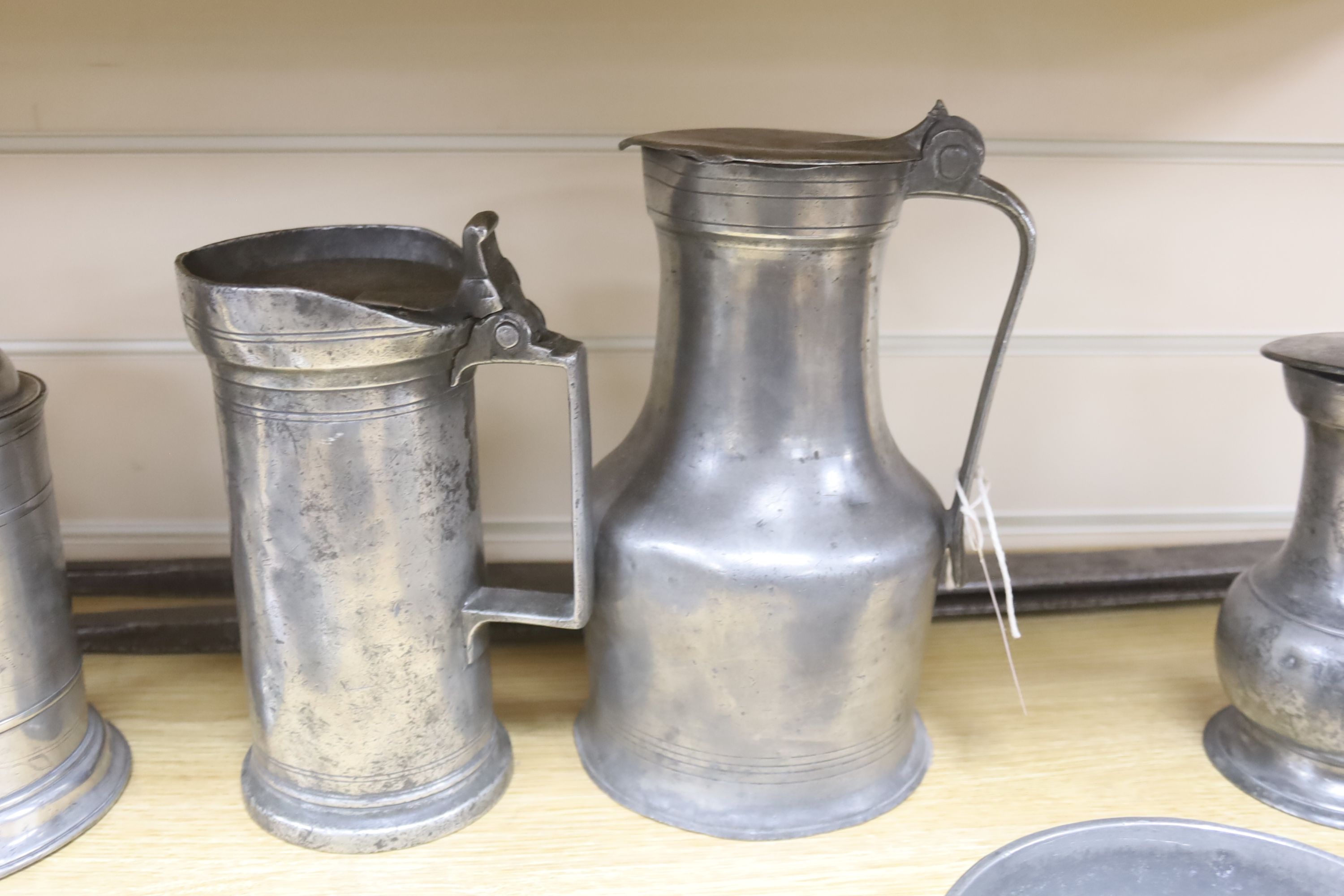 A large pair of steel dividers and a collection of 18th/19th century Continental pewter, including four various flagons, three candlesticks, a chamberstick and a porringer